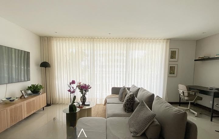 Cortina velada en sala con sofá gris
